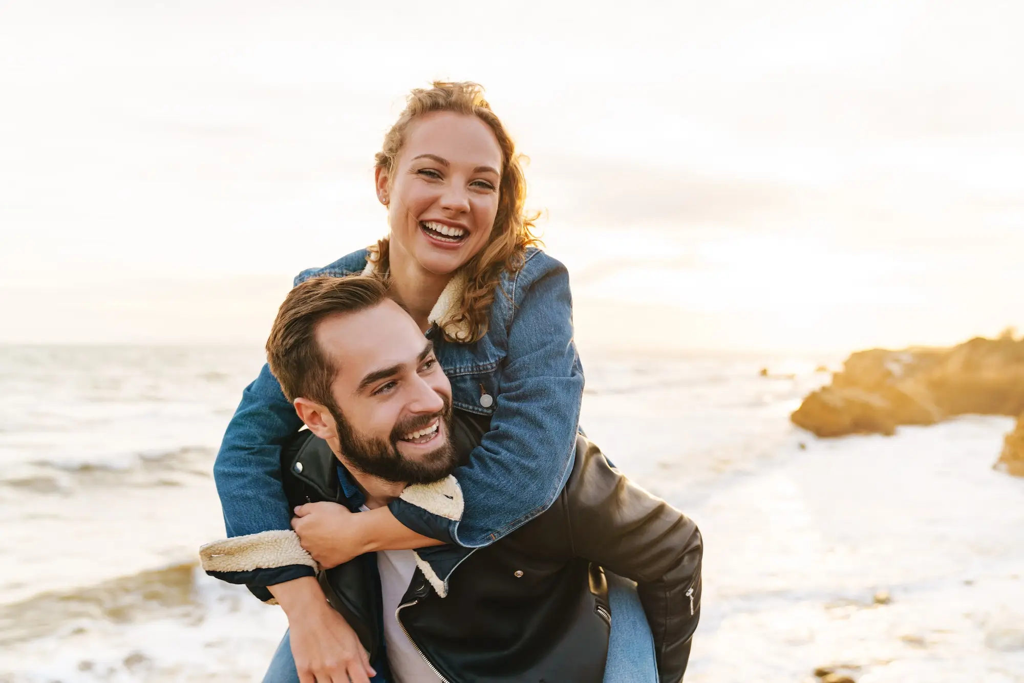 Image Of Beautiful Young Couple Piggybacking While Walking By Seaside